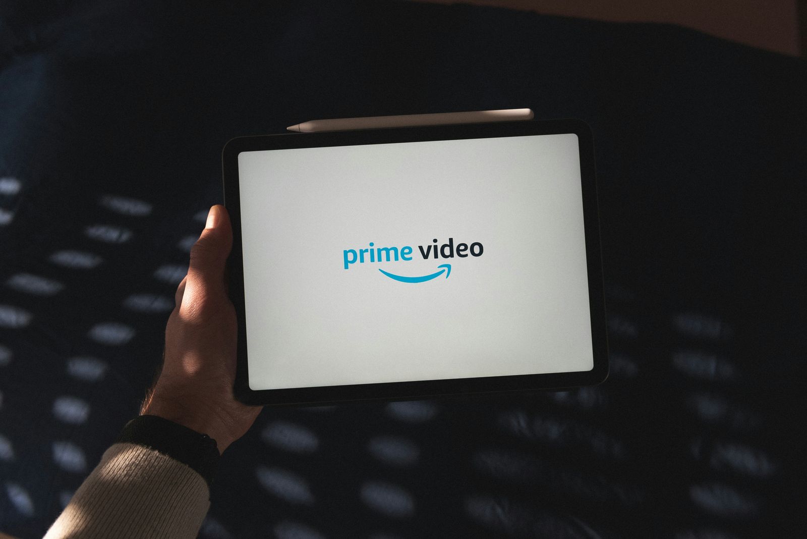 Person using a smartphone with a TV in the background